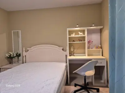 a bedroom with a bed and a desk and a chair at Abbie's Cozy Single Rooms in Maple Ridge District Municipality