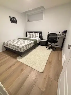 a bedroom with a bed and a desk and a chair at Chezeey Home in Edmonton