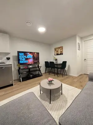 a living room with a couch and a tv and a table at Chezeey Home in Edmonton