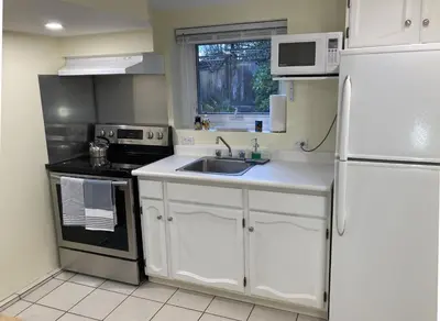 a kitchen with a white refrigerator and a sink at Private Suite in Vancouver in Vancouver