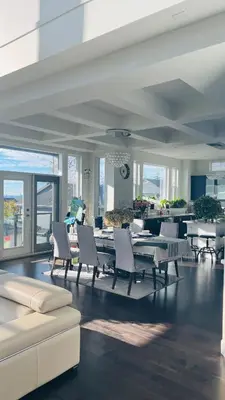a dining room with tables and white chairs in a building at Carrie's The Gentle Nest No 2 in Coquitlam