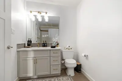 a bathroom with a sink and a toilet and a mirror at Entire Home - backyard oasis, indoor fireplace, Huge TV in Fort McMurray