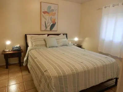 a bedroom with a bed with a striped comforter at Beach front cabin near Nelson, BC in Nelson