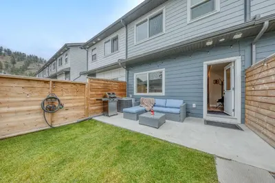 a backyard with a fence and a blue couch at Stunning NEW 3 Bedroom Mountain View Condo in Radium Hot Springs