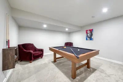 a room with a pool table and two chairs at Stunning NEW 3 Bedroom Mountain View Condo in Radium Hot Springs