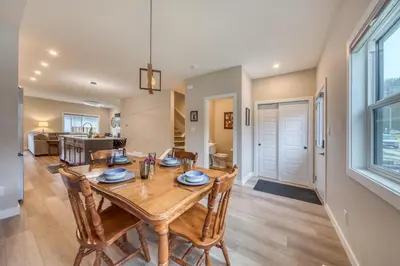 a dining room and living room with a wooden table and chairs at Stunning NEW 3 Bedroom Mountain View Condo in Radium Hot Springs