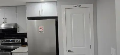 a kitchen with a white refrigerator in a kitchen at Glacier Comfort Living Suite in Calgary