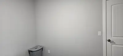 a white room with a remote control in a trash can at Glacier Comfort Living Suite in Calgary