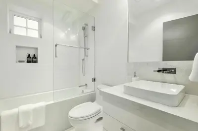 a white bathroom with a sink and a toilet at Kitsilano Retreat at Private 3 Bed with Parking and BBQ in Vancouver