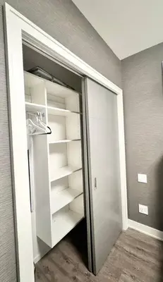 a walk in closet with white shelves in a room at Kitsilano Retreat at Private 3 Bed with Parking and BBQ in Vancouver