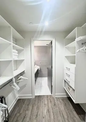 a walk in closet with white shelves and a door at Kitsilano Retreat at Private 3 Bed with Parking and BBQ in Vancouver