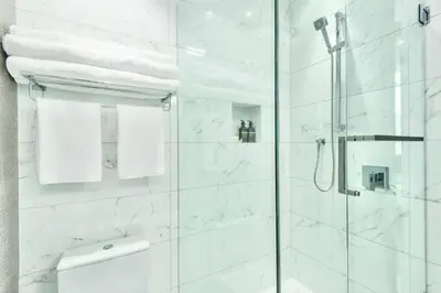 a bathroom with a shower with white marble at Kitsilano Retreat at Private 3 Bed with Parking and BBQ in Vancouver
