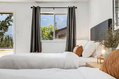two beds in a bedroom with a window at Gateway Suites Single Private Room Near Banff and Canmore in Canmore