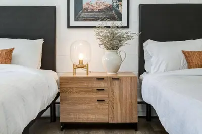 a bedroom with two beds and a table with a vase on it at Gateway Suites Single Private Room Near Banff and Canmore in Canmore