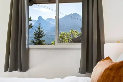 a bedroom with a window with a view of mountains at Gateway Suites Single Private Room Near Banff and Canmore in Canmore