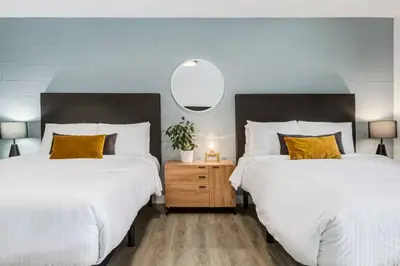 a bedroom with two beds and a mirror on the wall at Gateway Suites Private Double room Near Canmore and Banff in Canmore