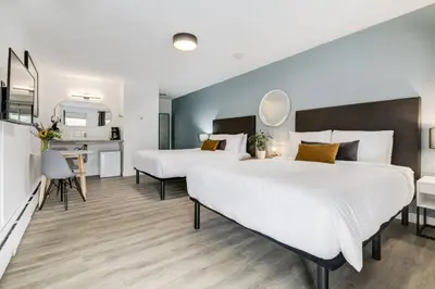a hotel room with two beds and a desk at Gateway Suites Private Double room Near Canmore and Banff in Canmore