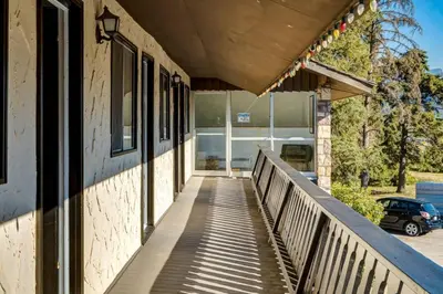 a walkway leading to a building with a car at Gateway Suites Private Double room Near Canmore and Banff in Canmore