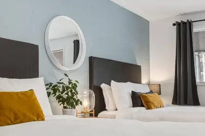 a bedroom with two beds and a mirror on the wall at Gateway Suites Private Double room Near Canmore and Banff in Canmore