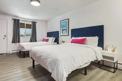 a bedroom with two beds with white and pink pillows at Gateway Suites Private Double room near Banff in Canmore