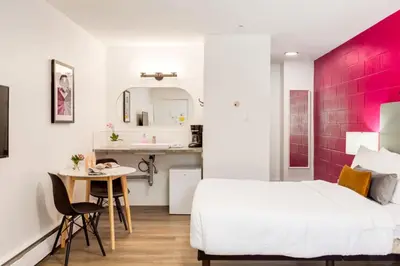 a bedroom with a white bed and a pink accent wall at Gateway Suites Rocky Mountains Private Double room close to Banff in Canmore