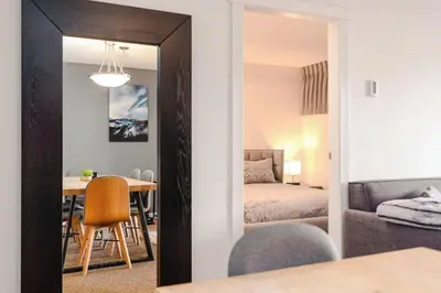 a living room with a table and a bedroom at Whistler Village Retreat, Private Hot Tub & Sauna in Whistler