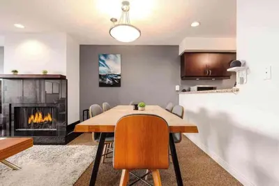 a dining room with a table and a fireplace at Whistler Village Retreat, Private Hot Tub & Sauna in Whistler