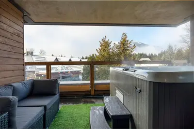 a living room with a couch and a sink on a balcony at Whistler Village Retreat, Private Hot Tub & Sauna in Whistler