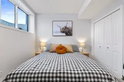 a bedroom with a bed with a black and white checkered blanket at Dont Overpay-2Bd 1 Bath -Calm Family Place in Calgary