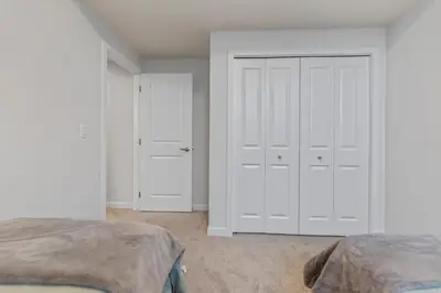 a bedroom with two white closets and two beds at Dont Overpay-2Bd 1 Bath -Calm Family Place in Calgary
