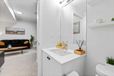 a white bathroom with a sink and a couch at Dont Overpay-2Bd 1 Bath -Calm Family Place in Calgary