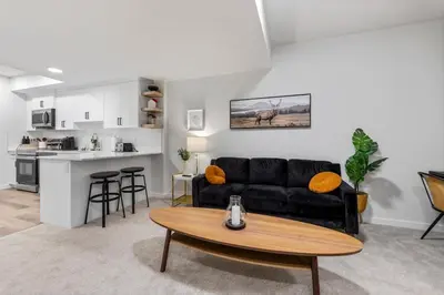 a living room with a black couch and a table at Dont Overpay-2Bd 1 Bath -Calm Family Place in Calgary