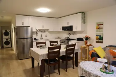 a kitchen and living room with a table and a refrigerator at Cozy Dreamscape in Surrey
