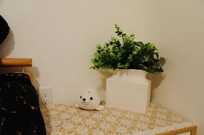 a teddy bear sitting on a table next to a potted plant at Cozy Dreamscape in Surrey