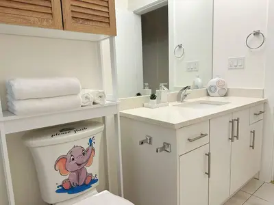 a bathroom with a toilet with a monkey sticker on it at Cozy Dreamscape in Surrey