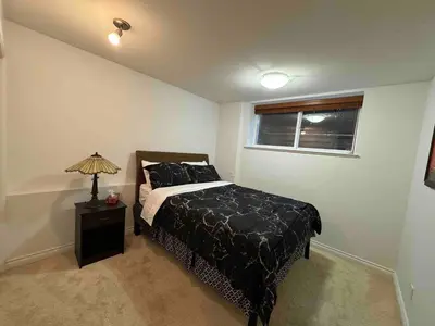 a bedroom with a bed and a lamp on a table at Adorable, 2 Bedrooms in West Vancouver in West Vancouver