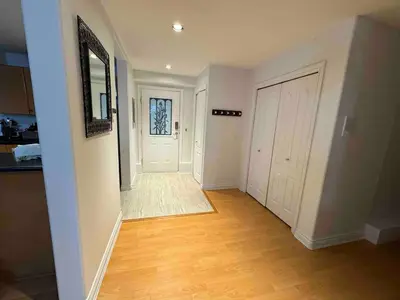 an empty hallway of a home with a door and wooden floors at Adorable, 2 Bedrooms in West Vancouver in West Vancouver