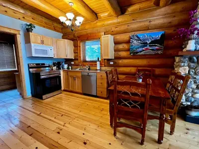 a kitchen with a table and chairs in a cabin at Chancellor Peak 1BR and Loft Wooden Cabin near Lake Louise in Golden