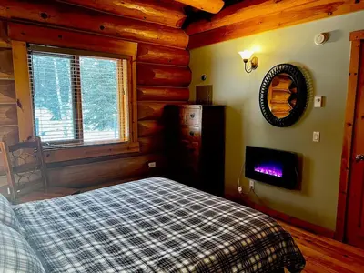a bedroom with a bed in a log cabin at Chancellor Peak 1BR and Loft Wooden Cabin near Lake Louise in Golden