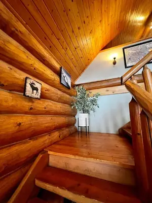 a staircase in a log cabin with a wooden ceiling at Chancellor Peak 1BR and Loft Wooden Cabin near Lake Louise in Golden