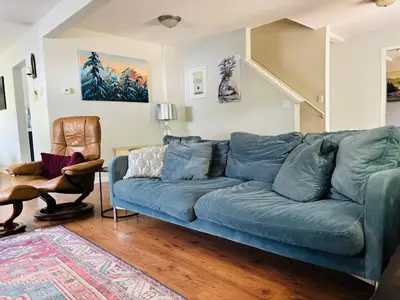 a living room with a blue couch and a chair at Pet friendly Family home in Shawnigan Lake in Shawnigan Lake