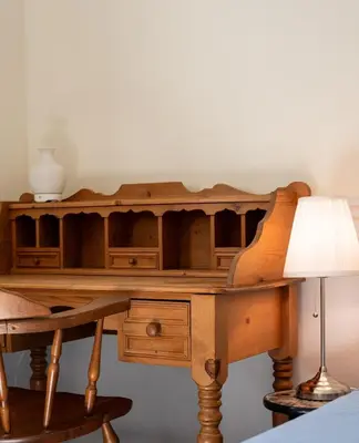 a wooden desk with a lamp and a table at Pet friendly Family home in Shawnigan Lake in Shawnigan Lake