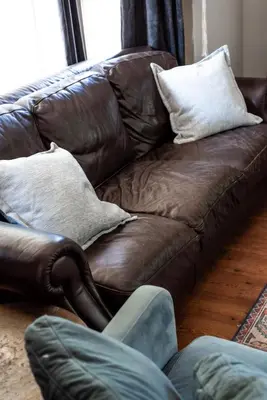 a brown leather couch sitting in a living room at Pet friendly Family home in Shawnigan Lake in Shawnigan Lake
