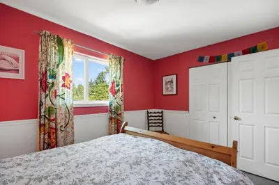 a bedroom with red walls and a bed and a window at Pet friendly Family home in Shawnigan Lake in Shawnigan Lake