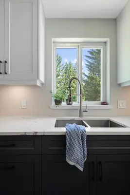 a white kitchen with a sink and a window at Pet friendly Family home in Shawnigan Lake in Shawnigan Lake