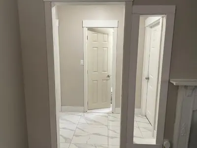 a hallway with two white doors and a tile floor at Central Vally Private House in Abbotsford