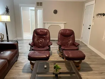 a living room with two leather chairs and a table at Central Vally Private House in Abbotsford