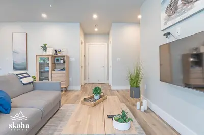 a living room with a couch and a tv at Skaha Suites in Penticton