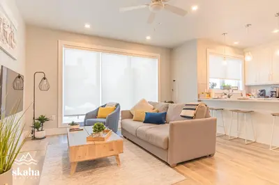 a living room with a couch and a kitchen at Skaha Suites in Penticton