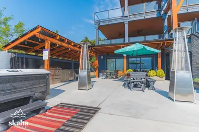 a building with a patio with a table and an umbrella at Skaha Suites in Penticton